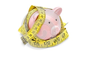 Piggy bank with measure tape on white background