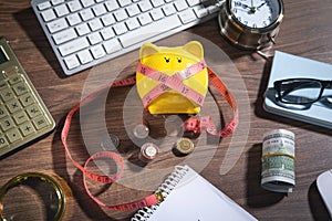 Piggy bank with measuring tape, coins and business objects