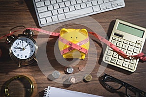 Piggy bank with measuring tape, coins and business objects