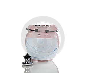 Piggy bank with medical mask and stethoscope on for financial crisis concept