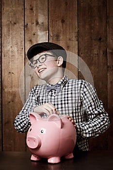 Piggy bank, money and boy child with savings, growth or investment, planning or learning at home. Happy, budget and kid
