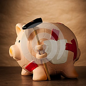 Piggy bank with money and hammer