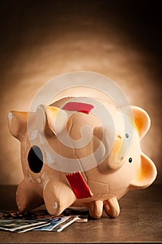 Piggy bank with money and hammer