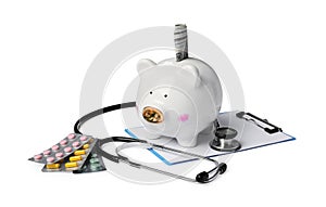 Piggy bank with money, stethoscope, clipboard and pills on white background. Medical insurance