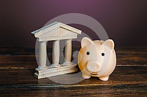 Piggy bank near the state building. Savings deposit in the bank. Use of investment instruments to increase funds, reduce