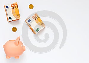 A piggy bank, paper money worth 50 euros and coins of 20 cents on a white background. The concept of preserving and increasing