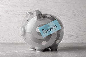 Piggy bank and paper with word PENSION