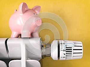 Piggy bank on radiator with radiator thermostat valve. Energy consumption saving concept