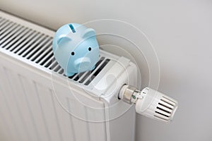 Piggy bank on radiator. Saving heating in winter