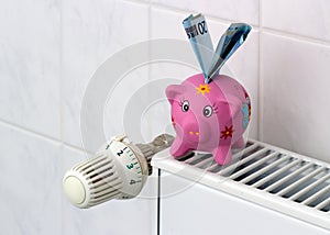 Piggy bank with radiator thermostat saving heating costs