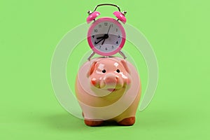 Piggy bank with retro alarm clock. Time is money concept.