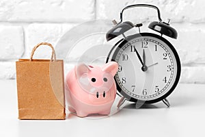 Piggy bank save coin and alarm clock, time and money concept.