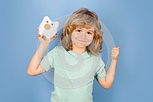 Piggy bank for saving money concept. Portrait of a child with money dollars banknotes isolated over studio background.