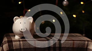 Piggy bank savings in Christmas tree background