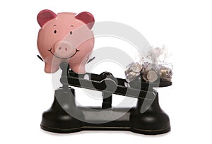 Piggy bank on scales with sterling money