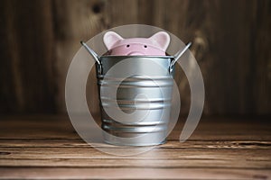 Piggy Bank Sinking Inside Steel Bucket