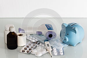 A piggy bank sits on top of pills to pay for rising drug prices. Health care