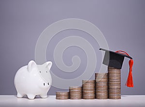 Piggy bank and stack of coins with graduation hat, The concept of saving money for education, student loan, scholarship, tuition