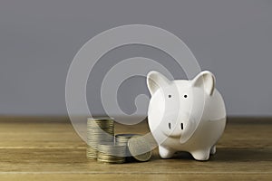 Piggy bank with stack coins an idea saving money on wooden table