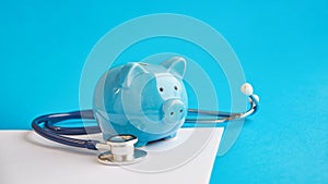 Piggy bank with stethoscope  on blue background. concept of financial literacy. Creating and maintaining a