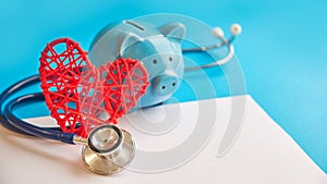 Piggy bank with stethoscope  on blue background. tax offset concept. Medical Expense Deductions and Tax Breaks