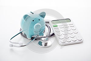 Piggy bank with stethoscope and calculator