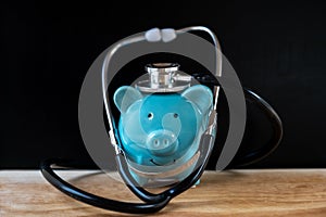 Piggy bank with stethoscope, check health savings regularly concept