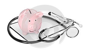 Piggy bank, stethoscope and clipboard on white background