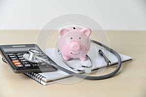 Piggy bank with stethoscope  financial checkup or saving for medical insurance costs