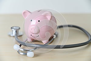 Piggy bank with stethoscope  financial checkup or saving for medical insurance costs