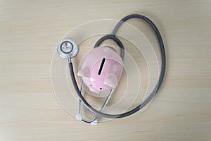 Piggy bank with stethoscope  financial checkup or saving for medical insurance costs