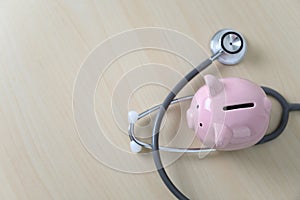 Piggy bank with stethoscope  financial checkup or saving for medical insurance costs