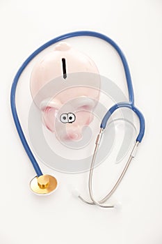 Piggy bank and stethoscope isolated