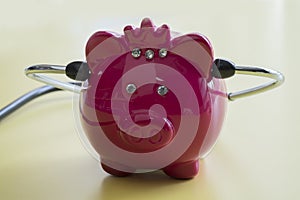 Piggy bank with stethoscope isolated