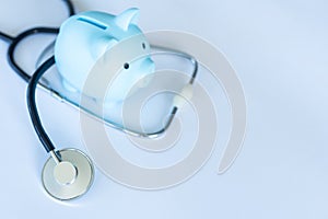 Piggy bank with stethoscope isolated on white.