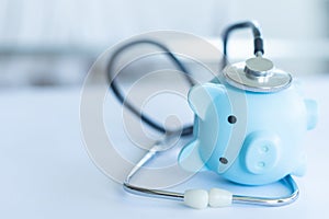 Piggy bank with stethoscope isolated on white.