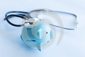 Piggy bank with stethoscope isolated on white.