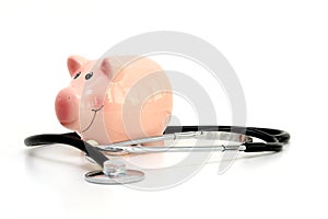 Piggy bank and Stethoscope Isolated on white background suggesting savings for medical cost