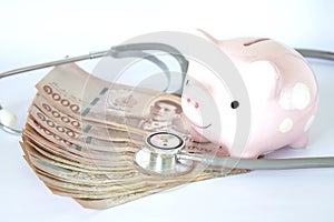 Piggy bank, Stethoscope and Thailand banknote on white background. Business concept. Concept for finance health check or cost of