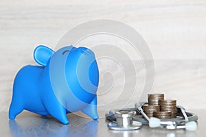 Piggy bank and stethoscope on wooden background, Save money for Medical insurance and Health care concept