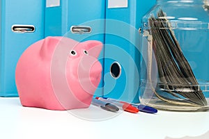 Piggy bank on the table in front of school subjects