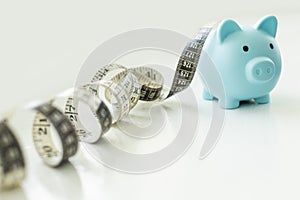 Piggy bank with tape measure on white background