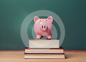 Piggy bank on top of books with chalkboard creating a cost of education theme