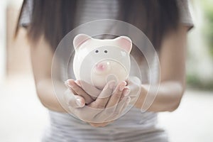 Piggy bank on woman hand  empty space background