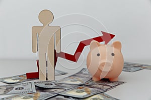 Piggy bank, wooden person with arrow up on dollar banknotes