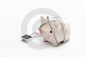 Piggy banks is lock by chain and key on white background