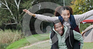 Piggyback, play or couple camping on holiday vacation or fun weekend break at outdoors together. Freedom, interracial