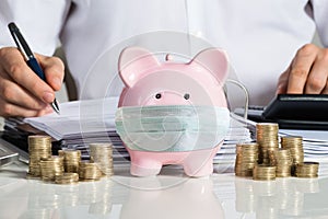 Piggybank With Face Mask Near Accountant