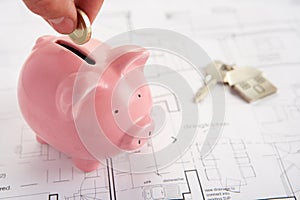 Piggybank with house plans and keys photo