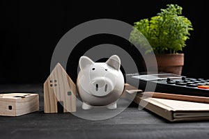 Piggybank and Small wooden houses with modern design and calculator for home loans concept